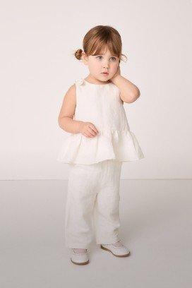 a little girl in a white set