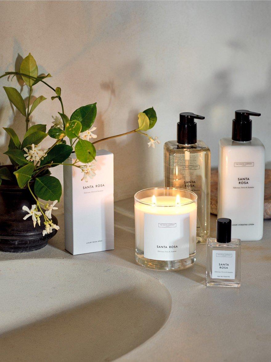a bathroom counter with a vase of flowers and a candle