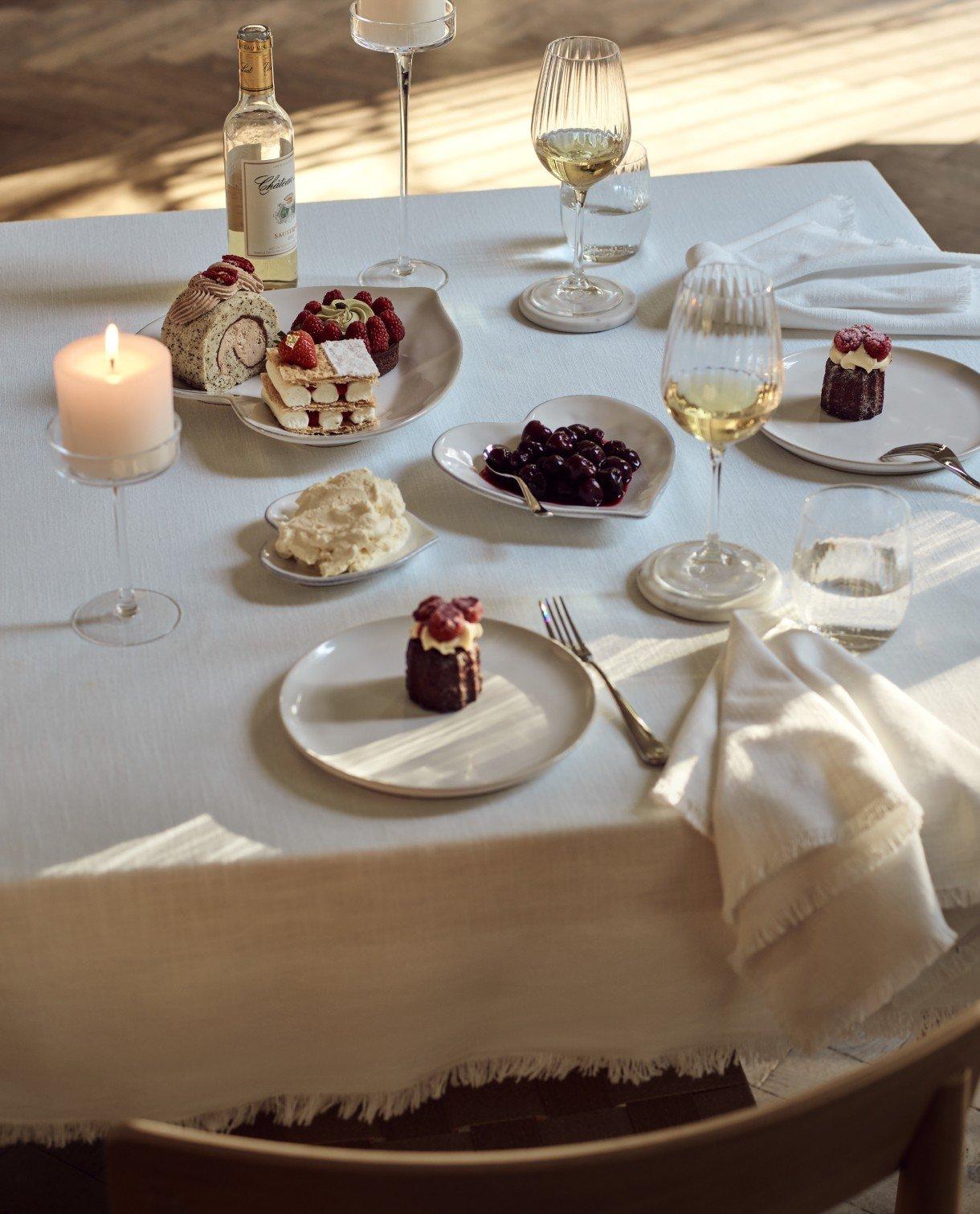 a table with a white cloth and candles on it