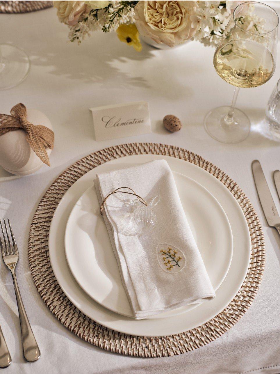 a white plate with a white napkin on it next to silverware