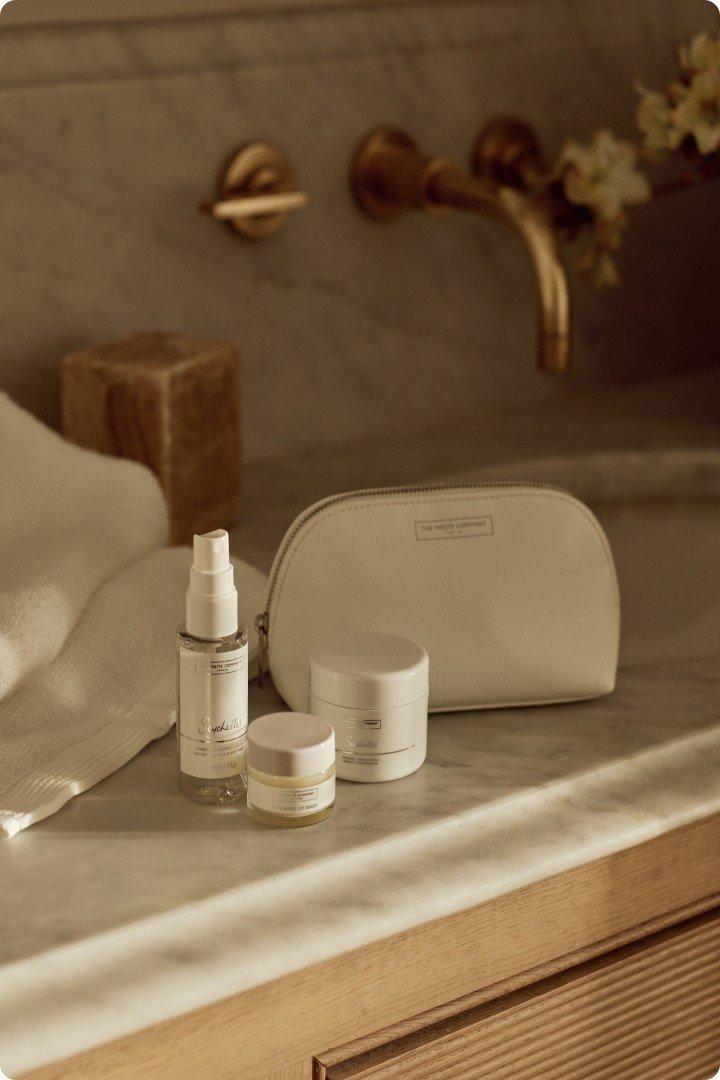 a bathroom counter with a white bag and a bottle of lotion