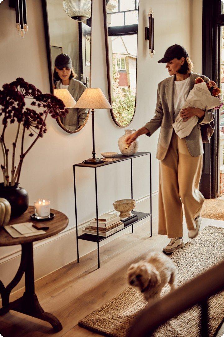 a woman walking with a dog and a baby in a house