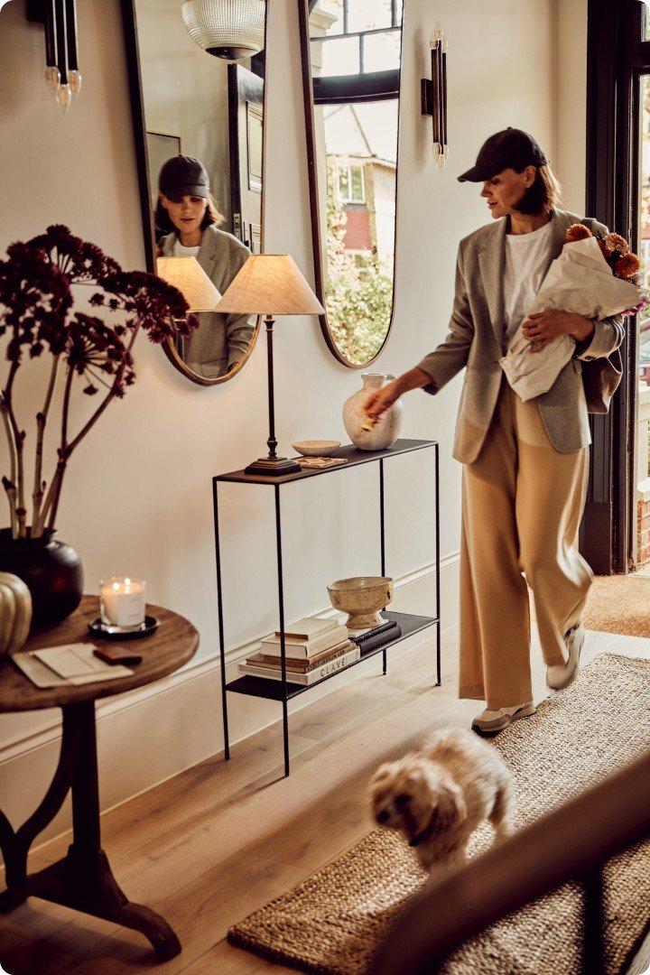 a woman walking with a dog and a baby in a house