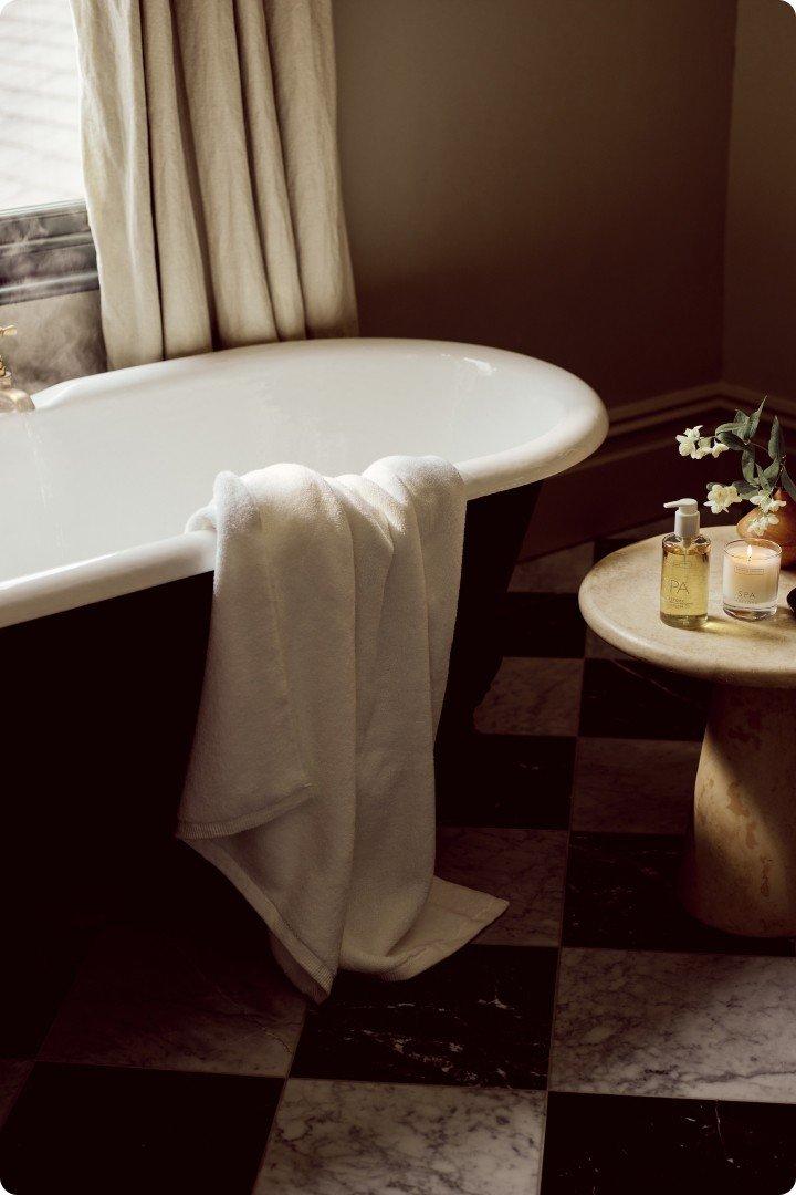 a bathtub sitting in a room with a checkered floor