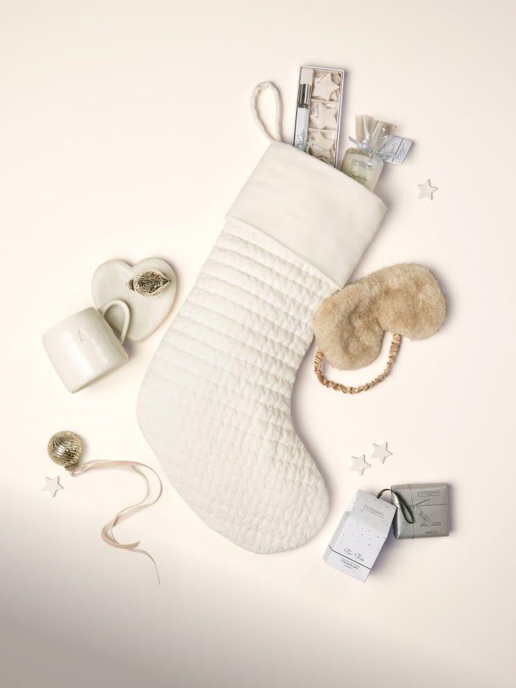 a white stocking with a bow on it and a gift