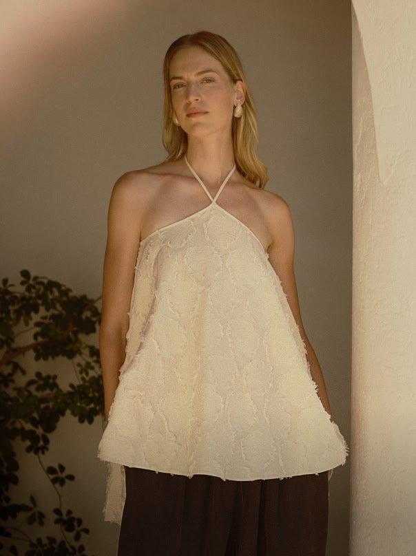 a woman in a white top posing for a picture