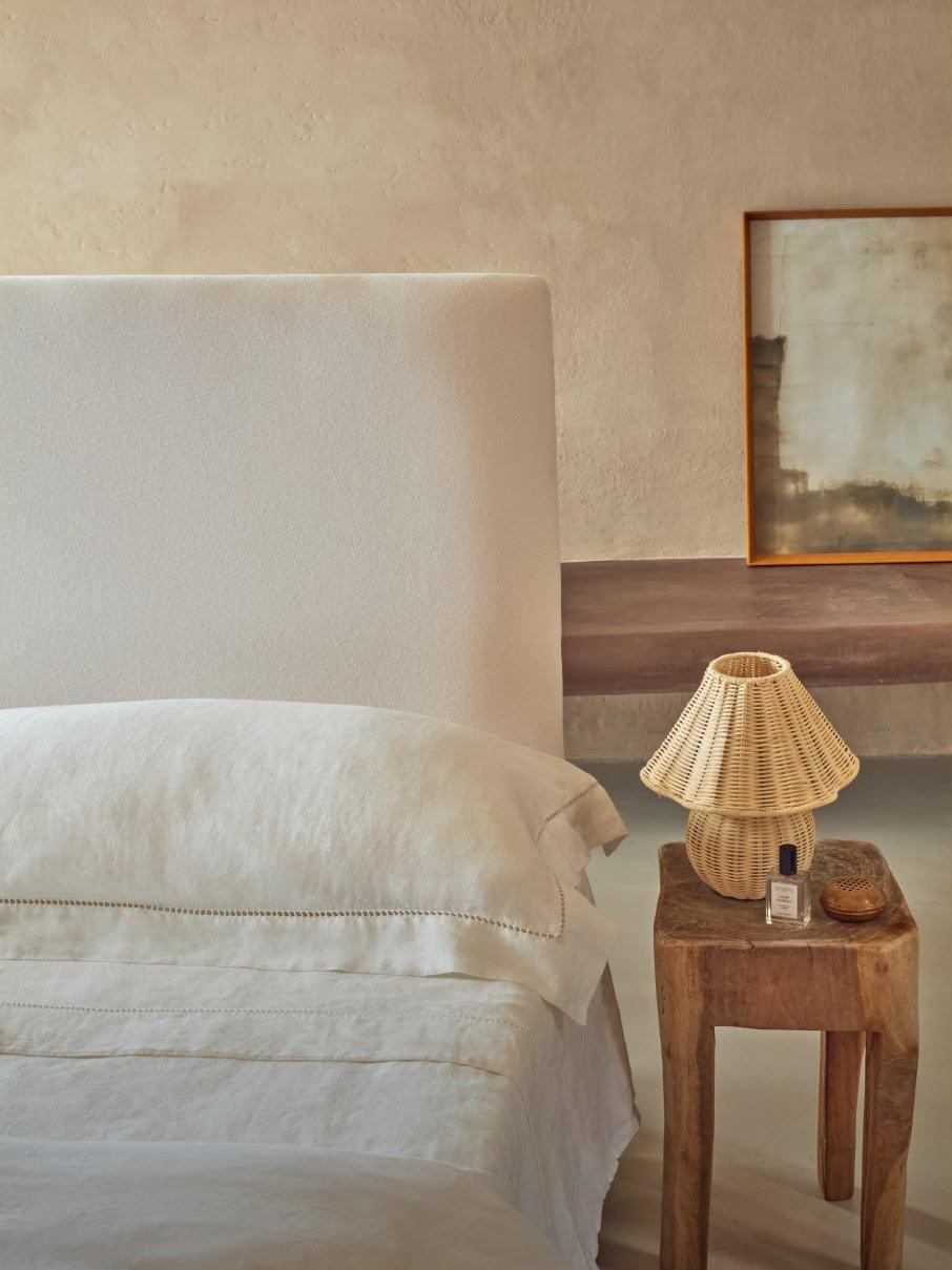 a bed with white sheets and pillows in a bedroom