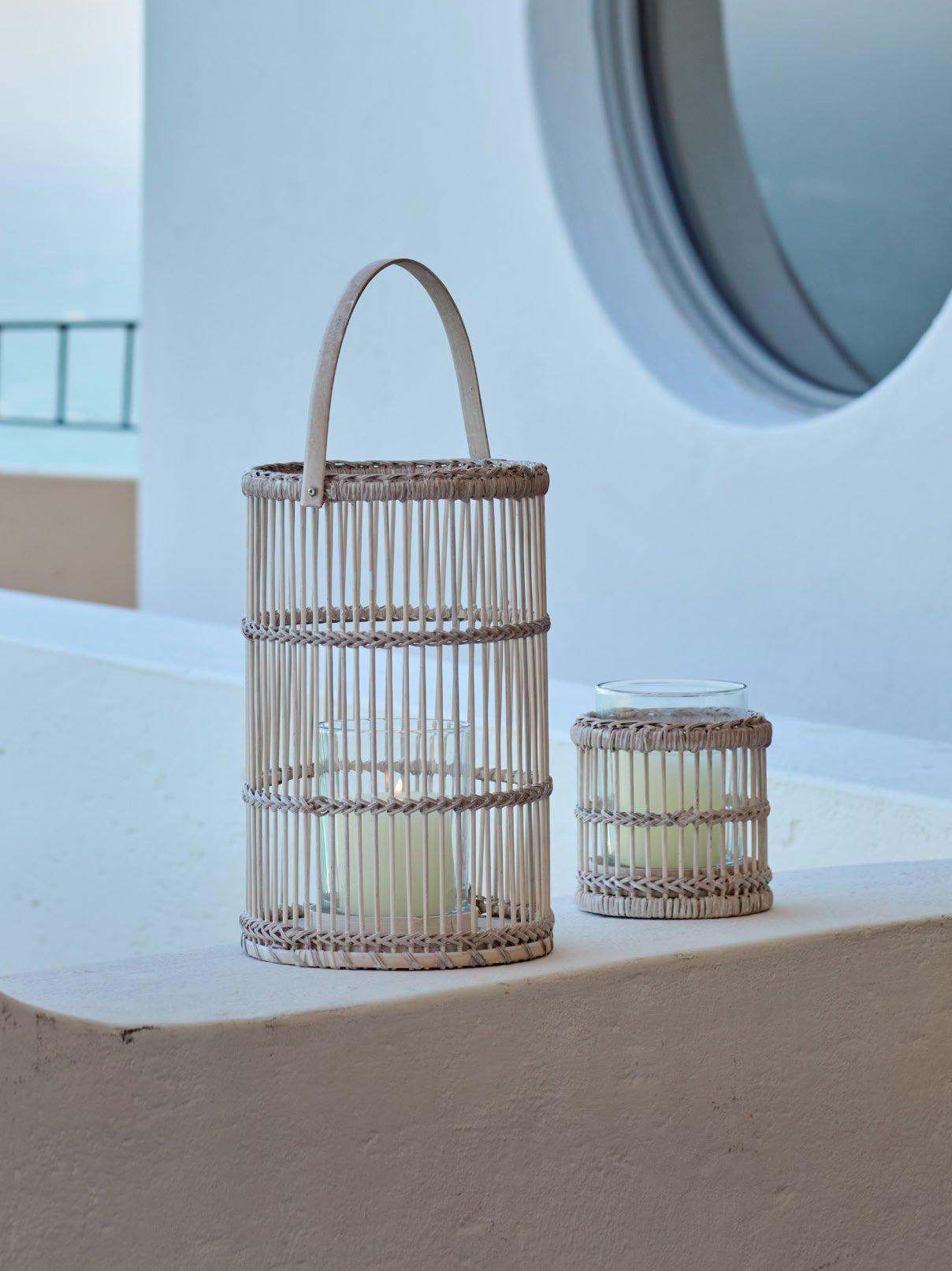 two small white candle holders sitting on a ledge next to a window
