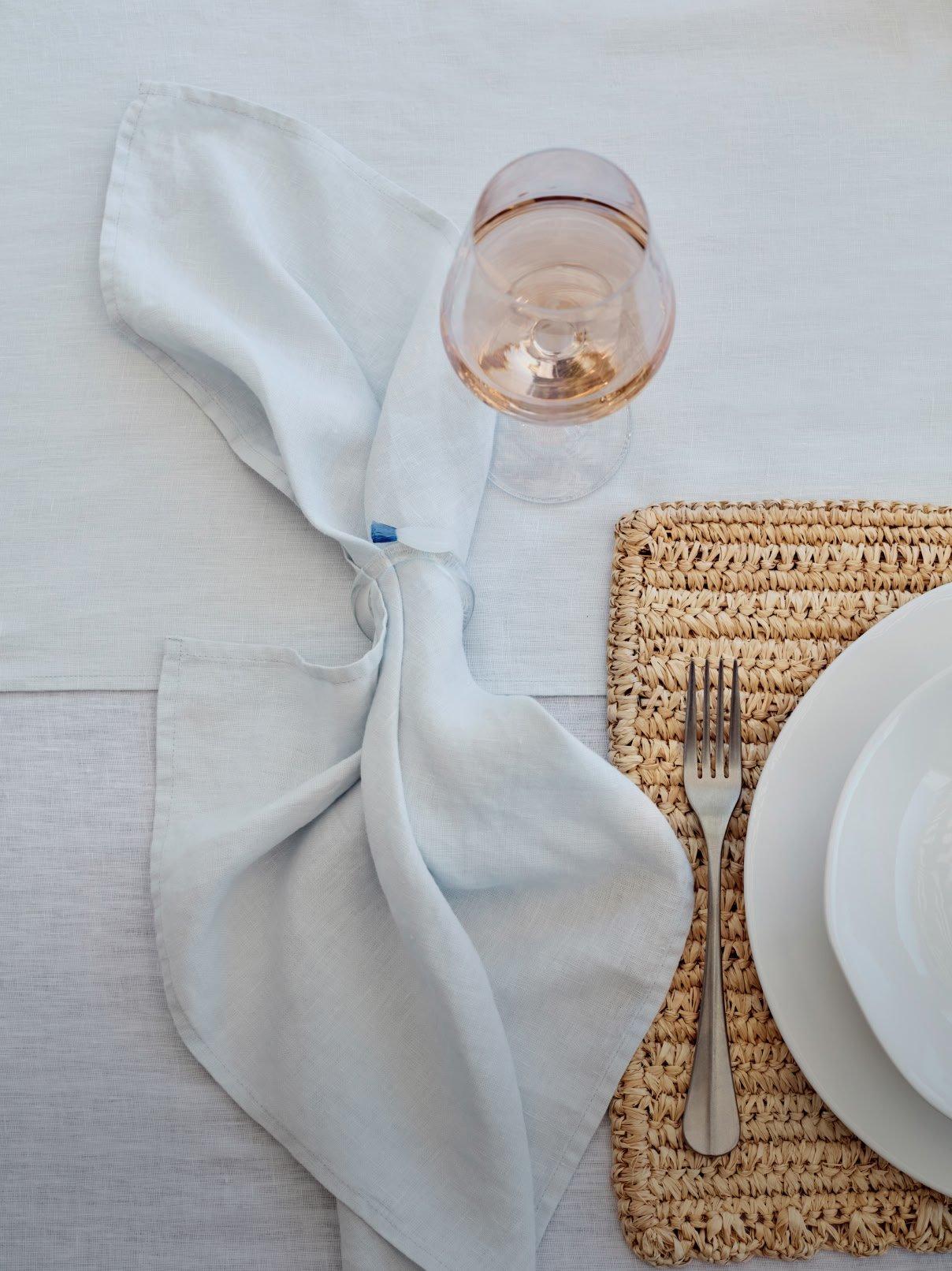 a white napkin on a table with a fork and a glass