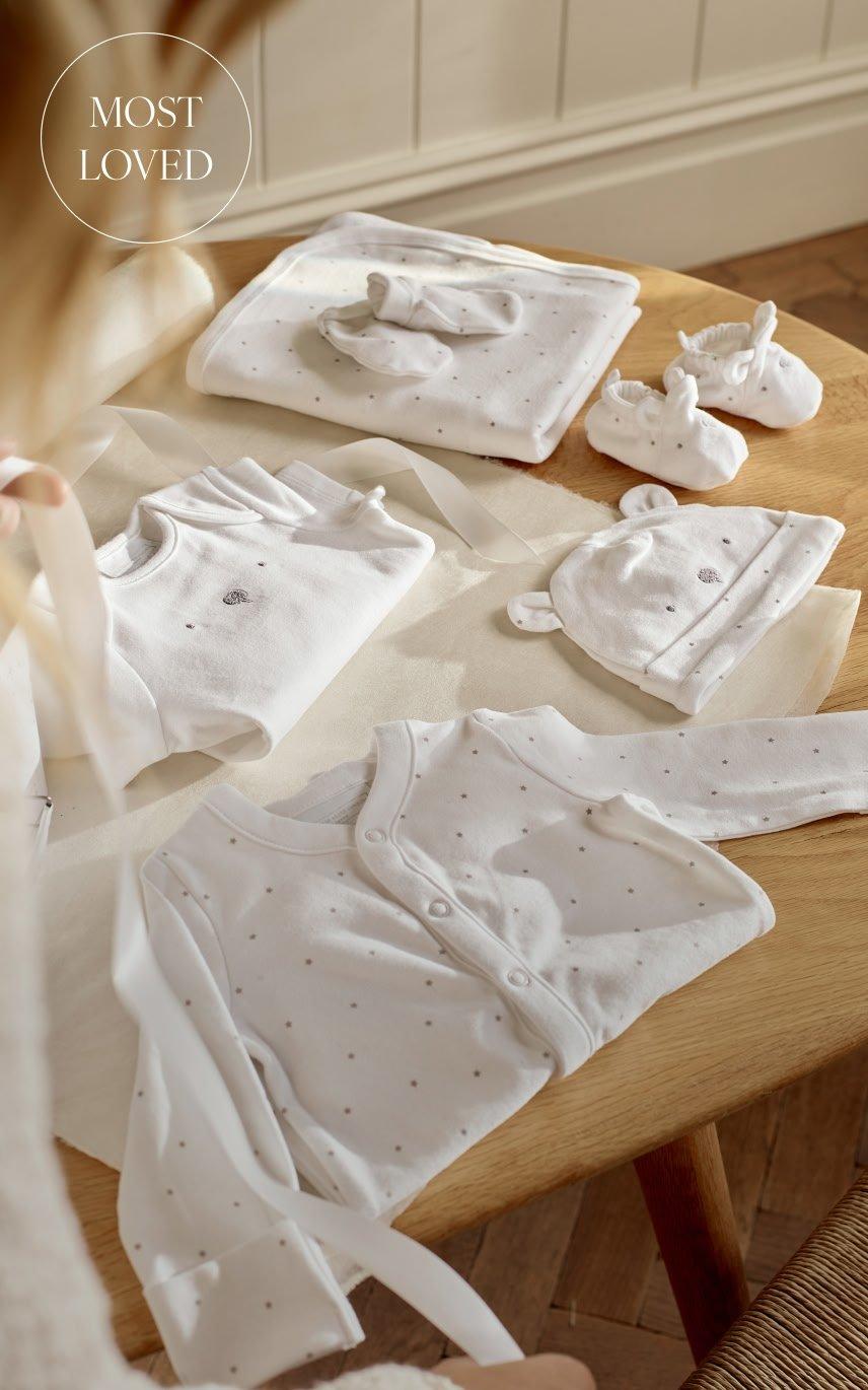 a table with a baby's clothes laid out on it
