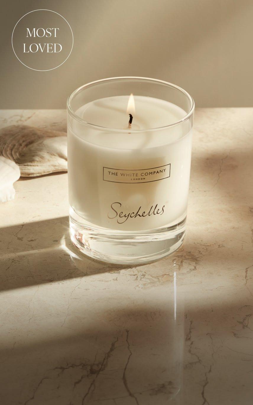 a candle is sitting on a table next to a book