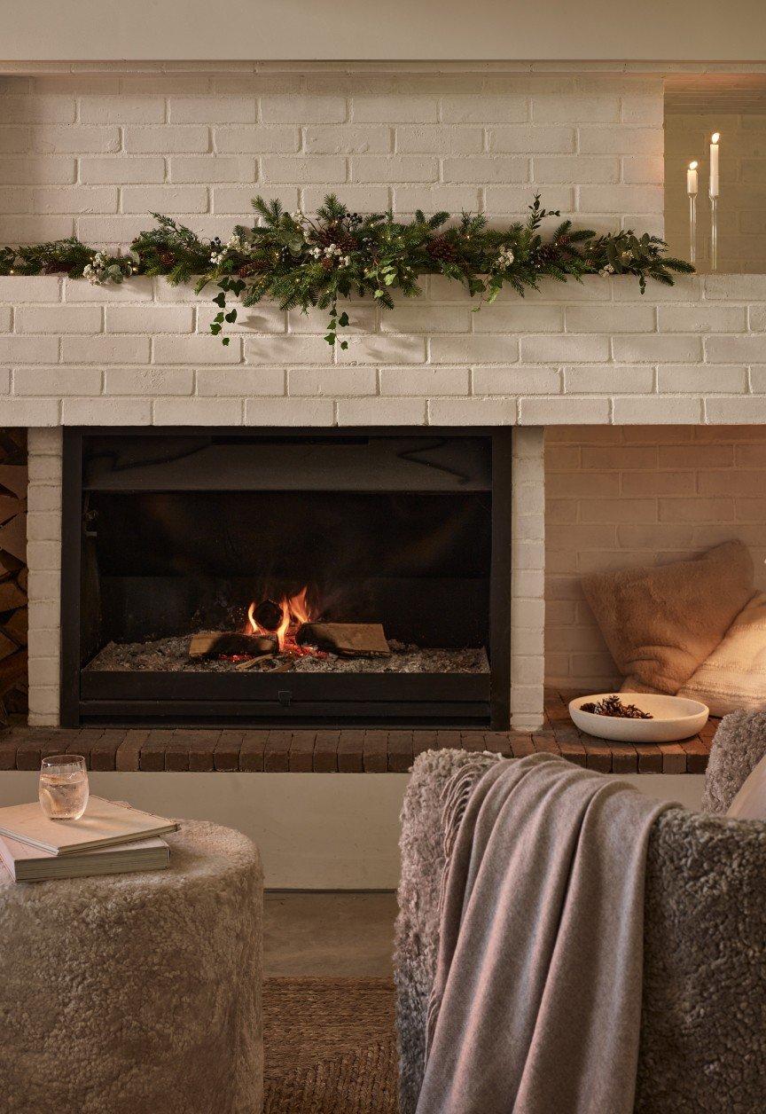 a fireplace with a mantle and a grey couch in front of it