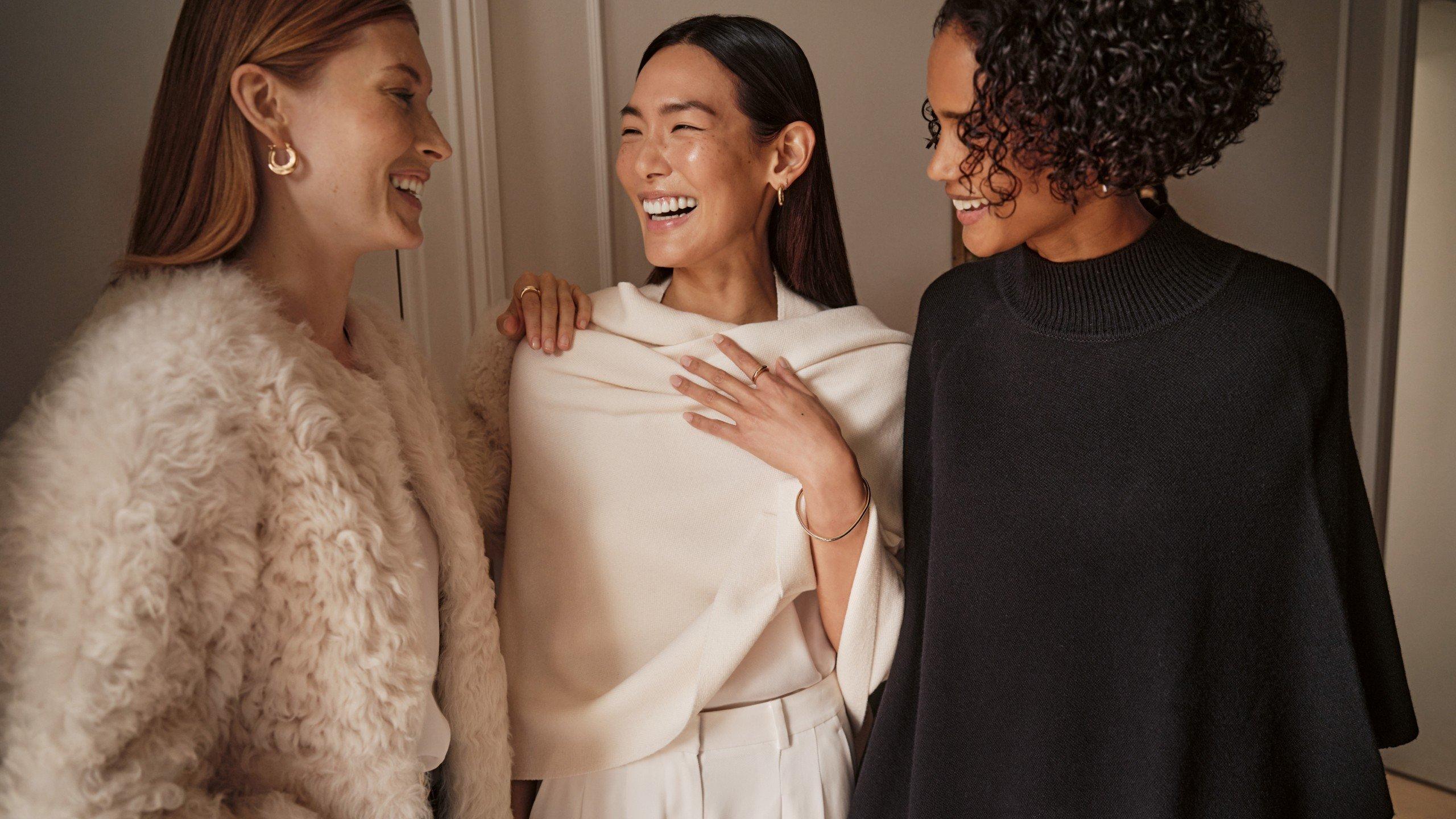 three women are smiling and laughing together