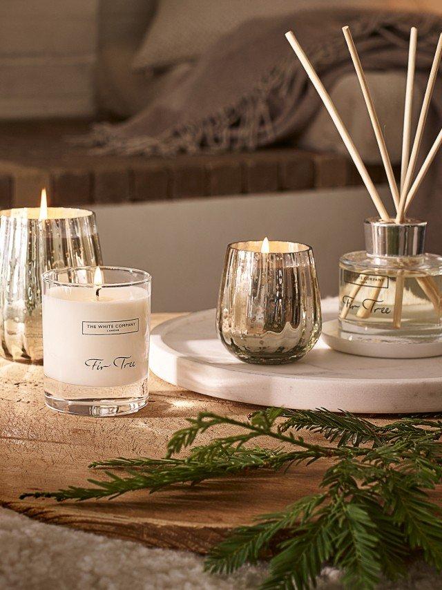 a table with candles, a diffuser and a plant on it