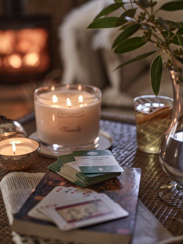 a table with a candle, cards, and a book on it