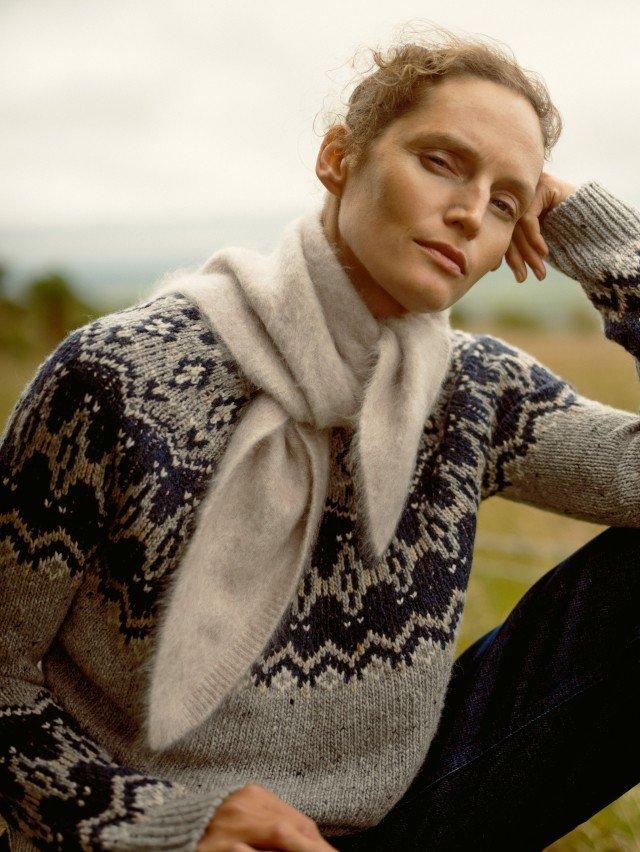 a woman sitting on a bench with her hands on her chin