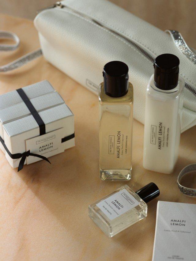 a white bag with a white purse and a bottle of perfume