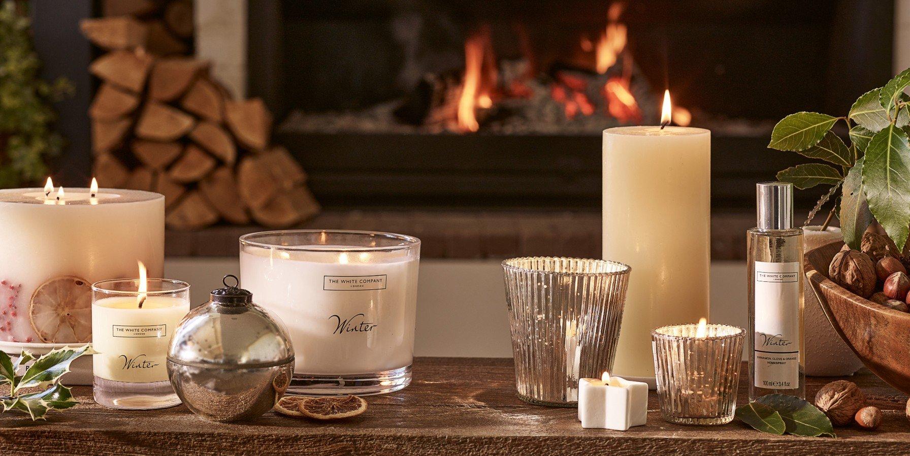 a candle on a table next to a vase and a piece of paper