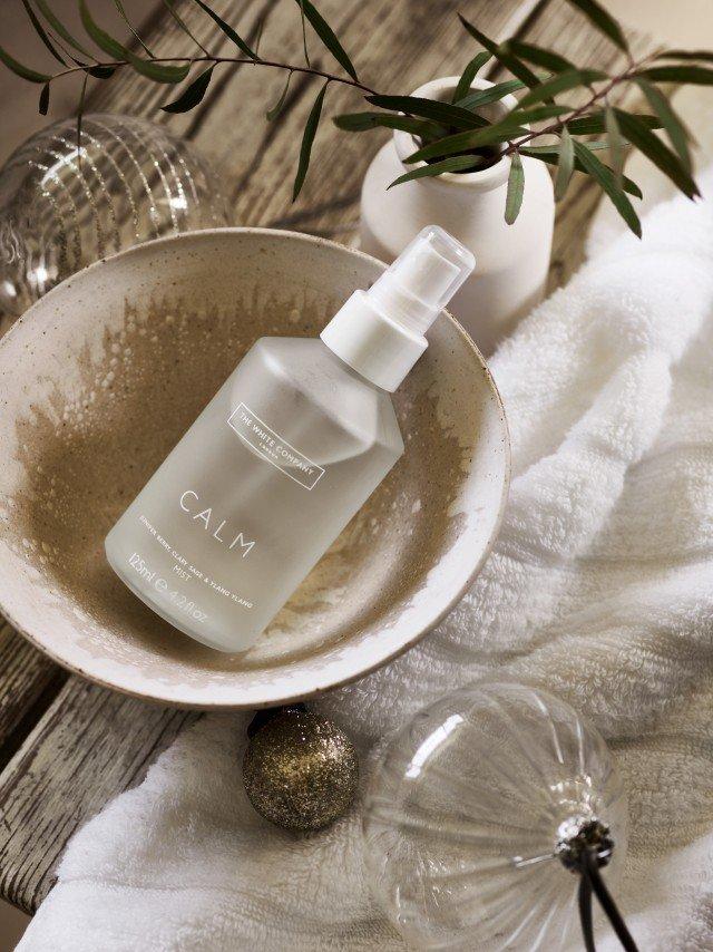 a glass bowl with a bottle of water sitting on top of it