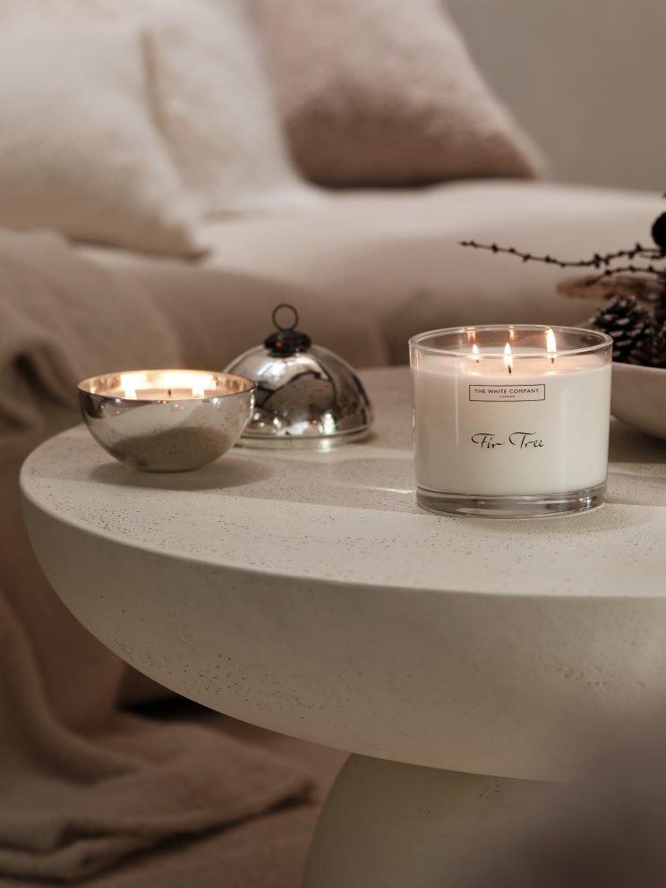 a table with candles and a vase on it in a room