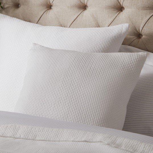 a close up of a bed with pillows and a headboard