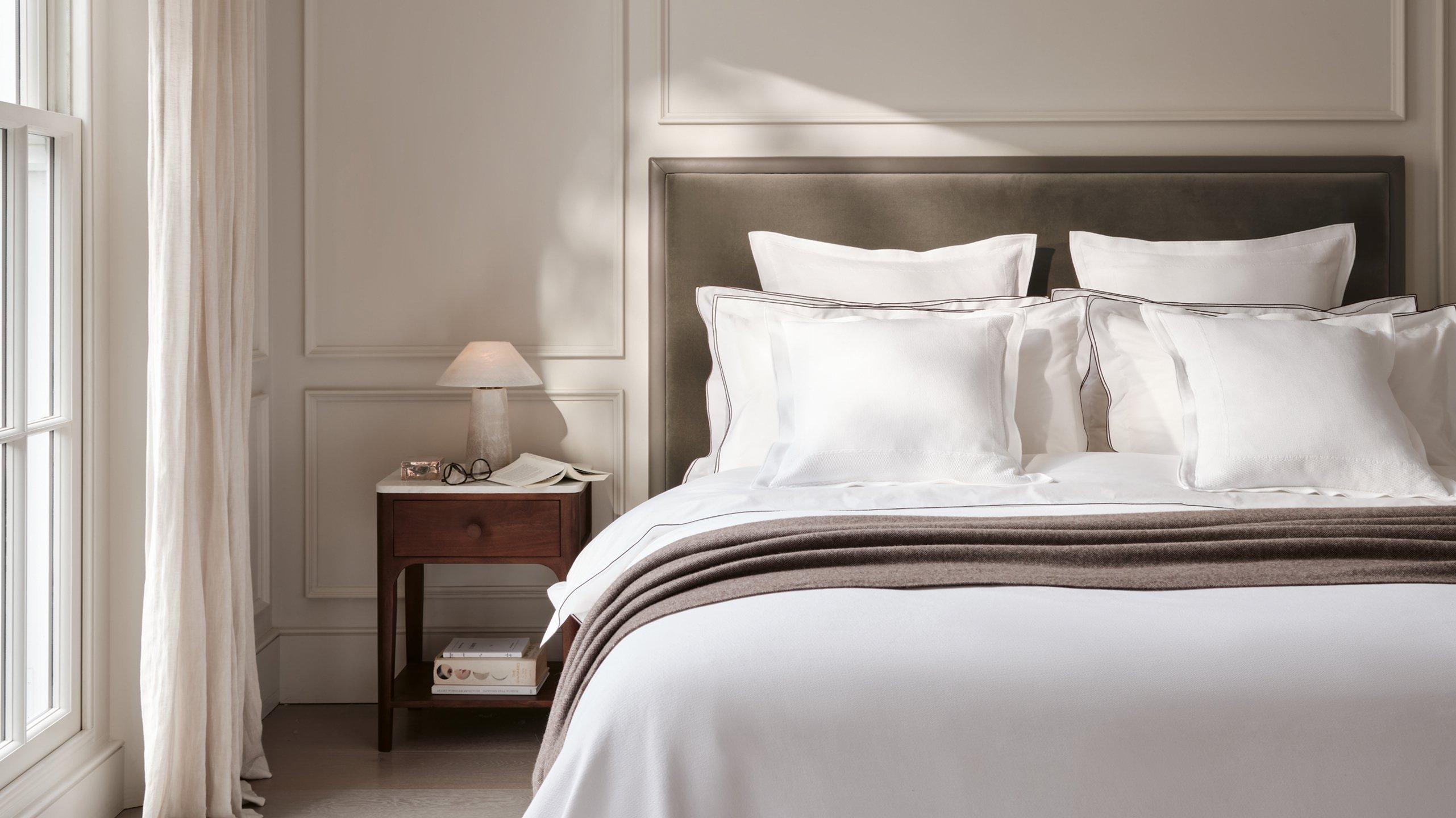 a bedroom with a bed, a table and a lamp