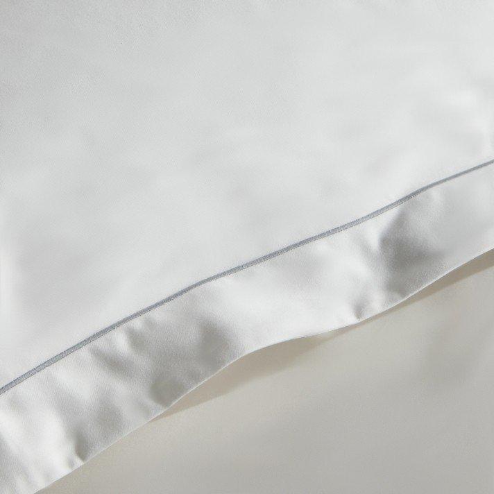 a close up of a white pillow with a silver lining