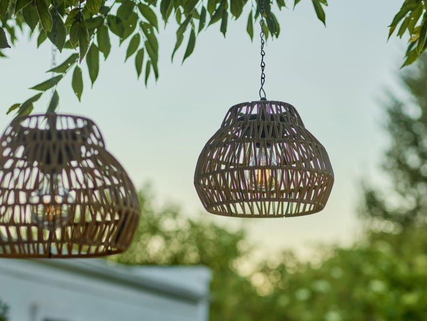 two hanging lamps with wicker shades hanging from trees