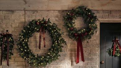 a group of wreaths hanging from a brick wall with lights