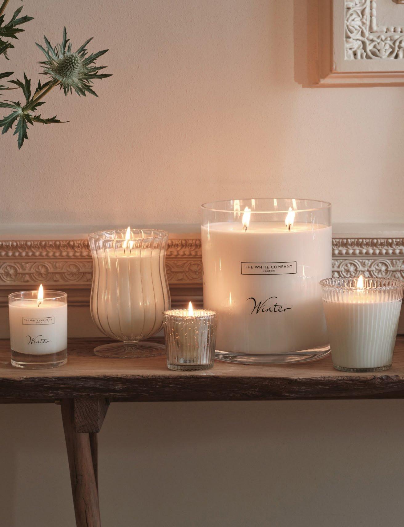a table with candles and a plant on it in a room