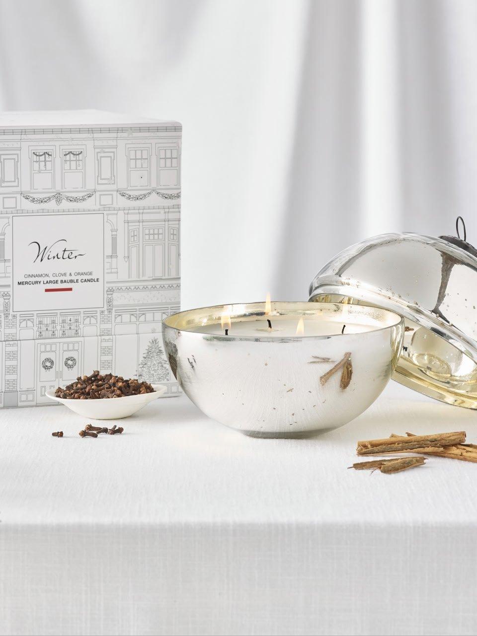 a silver bowl with a candle and a box of spices
