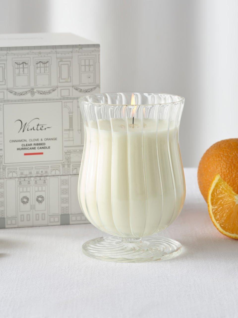 a candle and orange slices on a table next to a box
