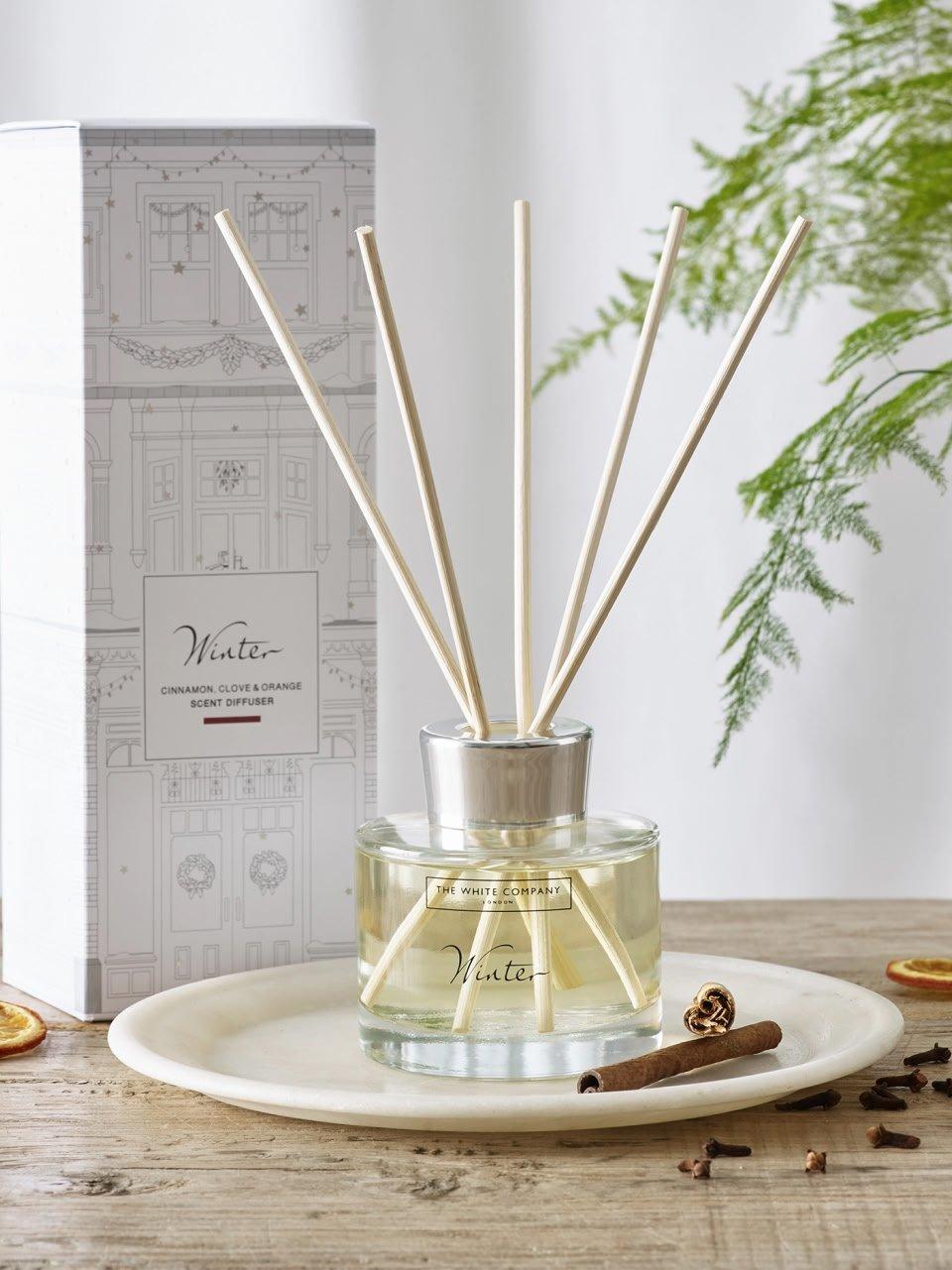 a white plate with a reed diffuser on it next to a box of spices
