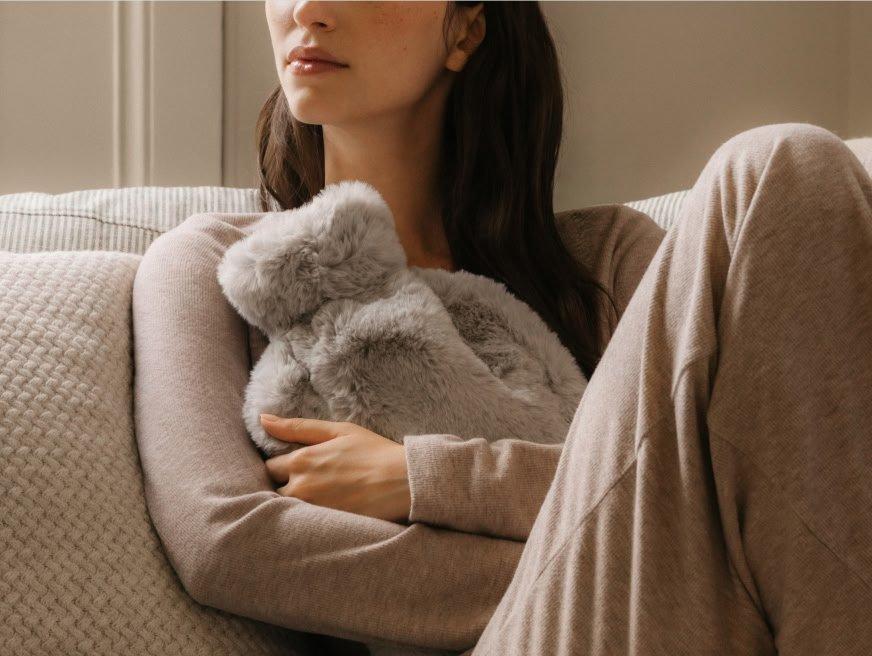 a woman sitting on a couch holding a stuffed animal