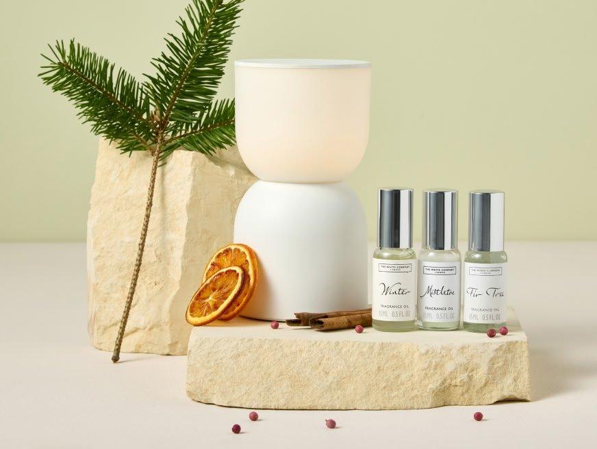a bottle of perfume, a candle and a small tree