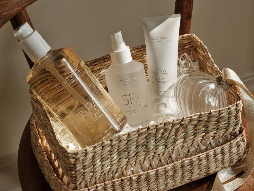 a basket with a bottle of lotion, a bottle of shampoo, and a bottle of condition