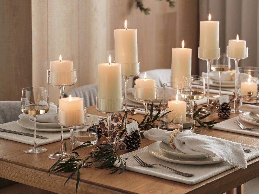 a table set with candles and plates and silverware