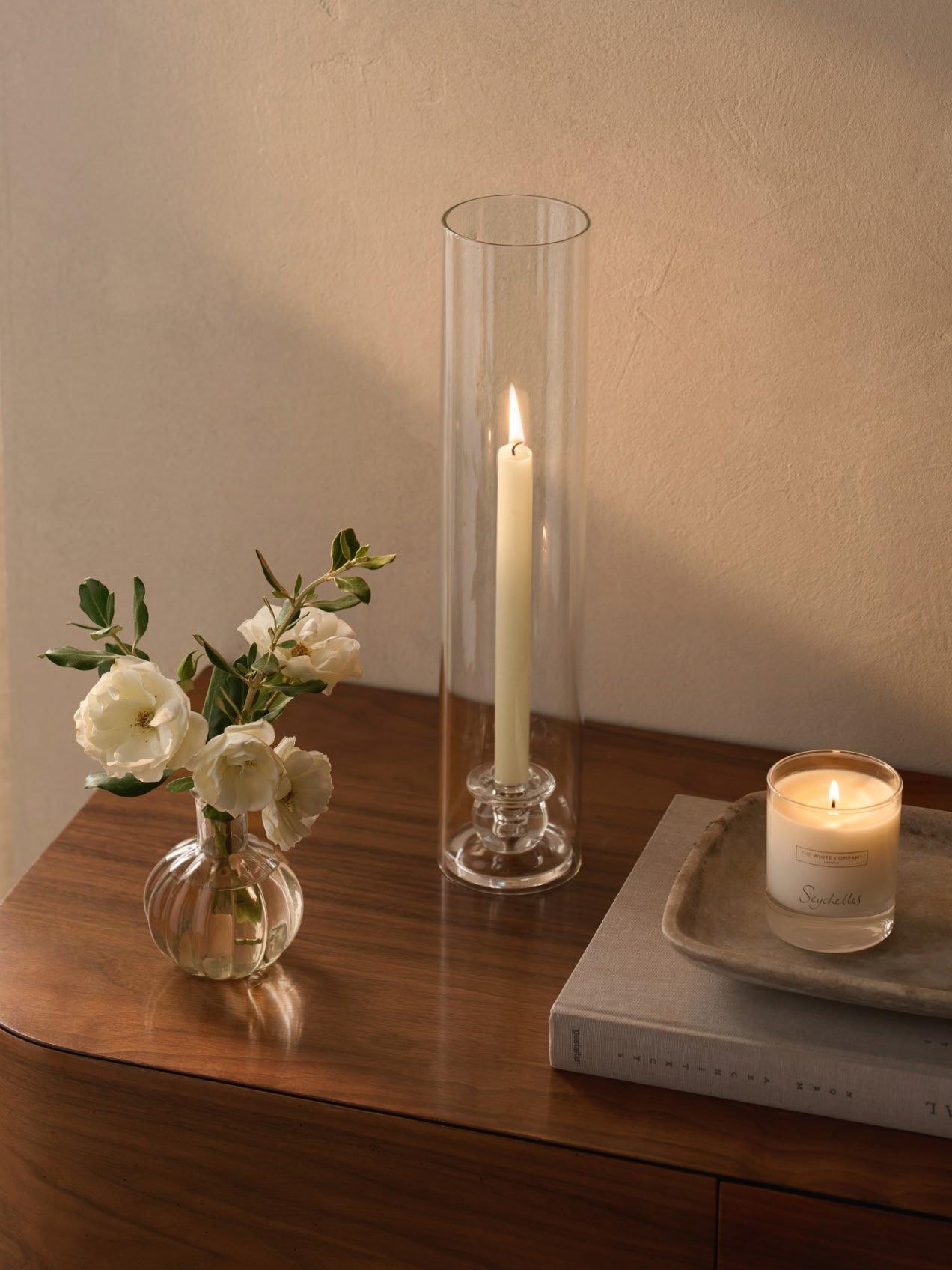 a candle and a vase of flowers on a table