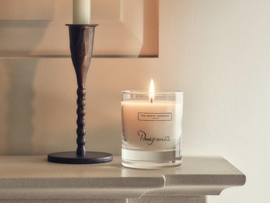 a candle sitting on a mantle next to a candle holder