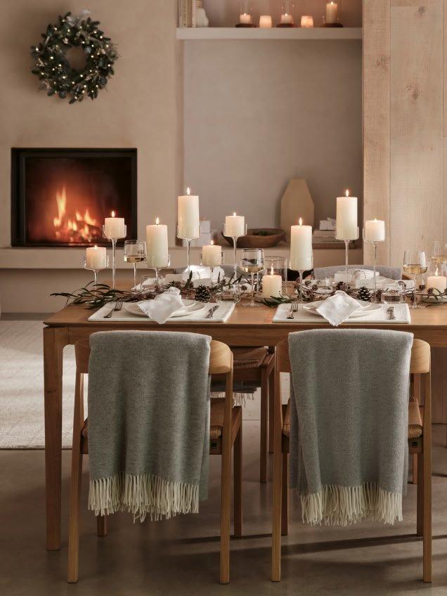 a dining room with candles and a fireplace in the background
