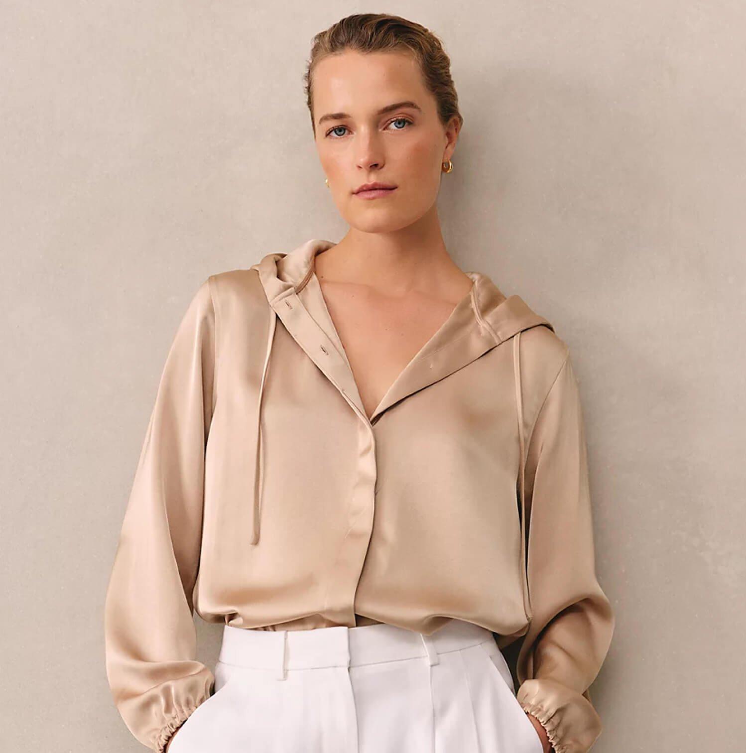 a woman in a white dress standing against a wall