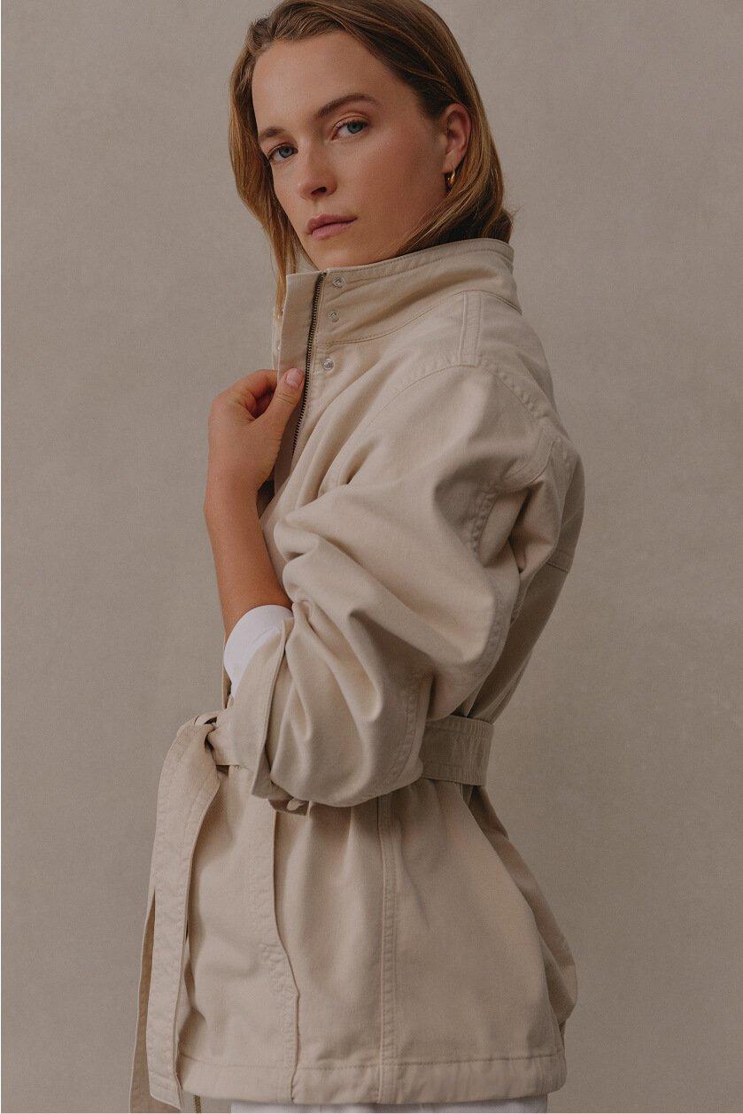 a woman in a white jacket posing for a picture