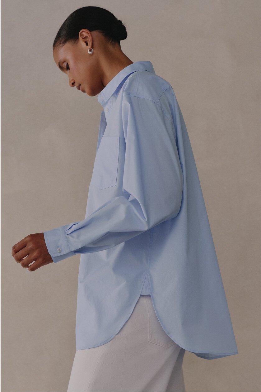 a woman in white pants and a blue shirt walking