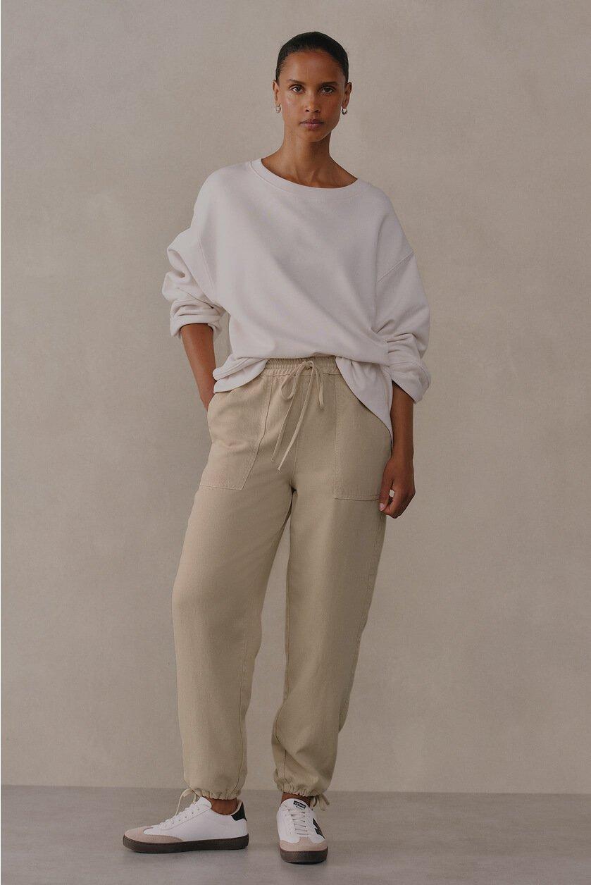 a woman in a white sweatshirt and white sneakers