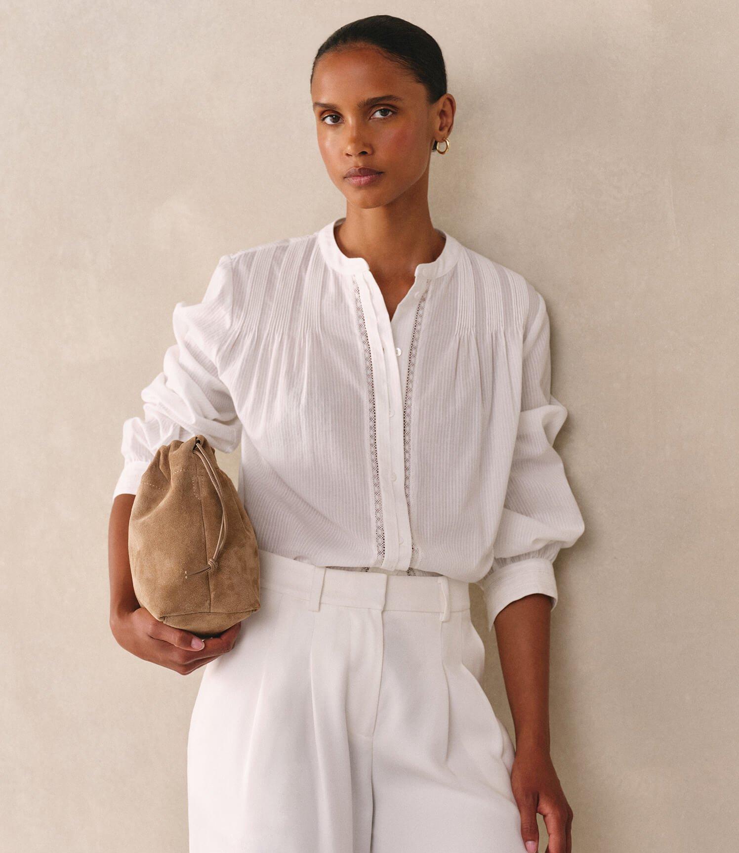 a woman in white pants and a blue shirt walking