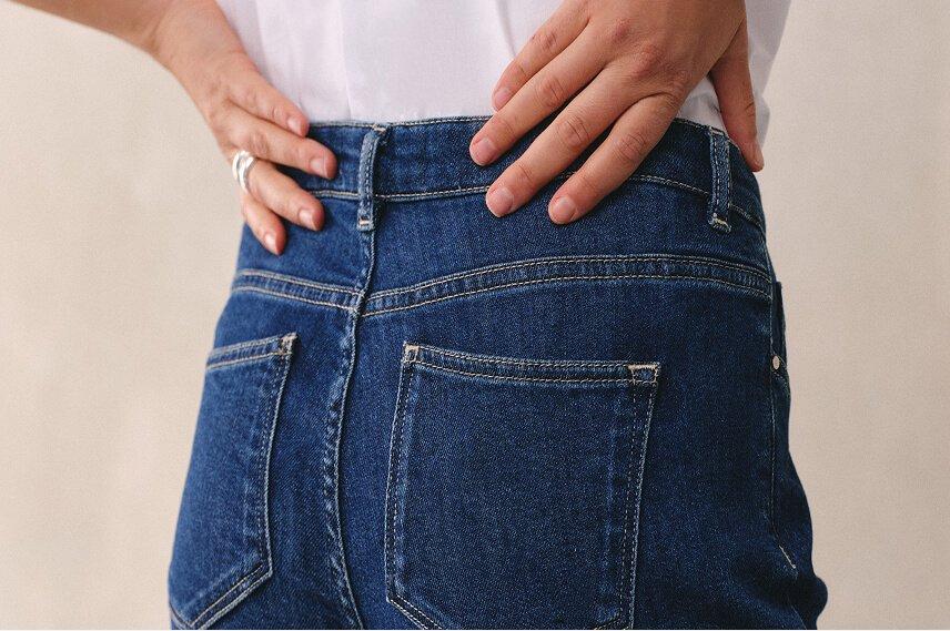 a woman in a pair of blue jeans with her back to the camera