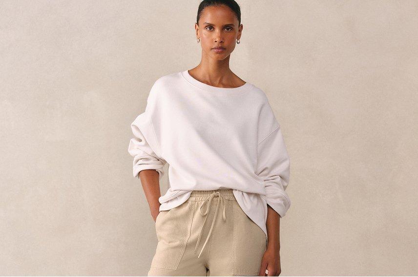 a woman in beige pants and a white shirt posing for a picture