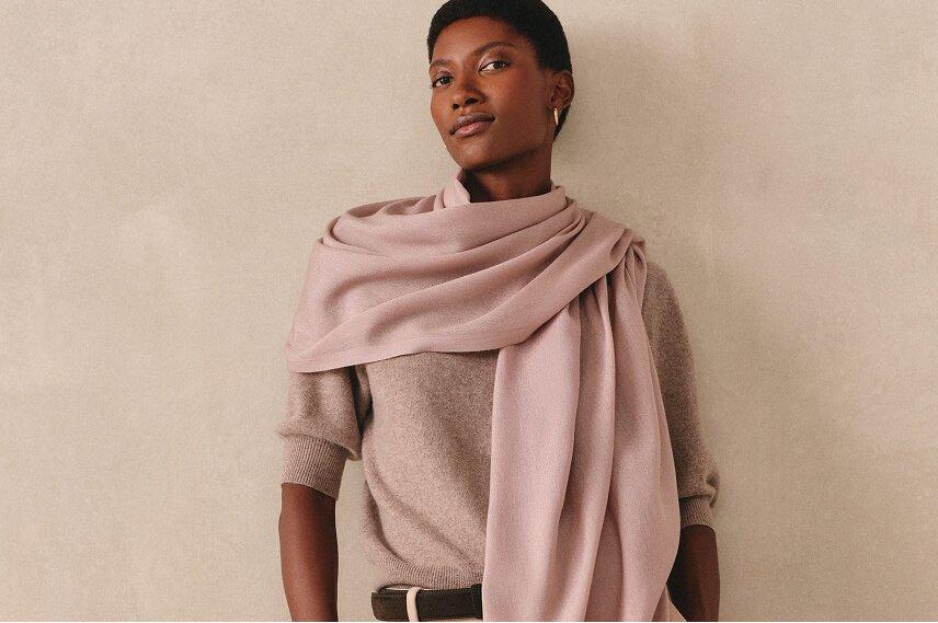 a woman in a sweater and scarf posing for a picture