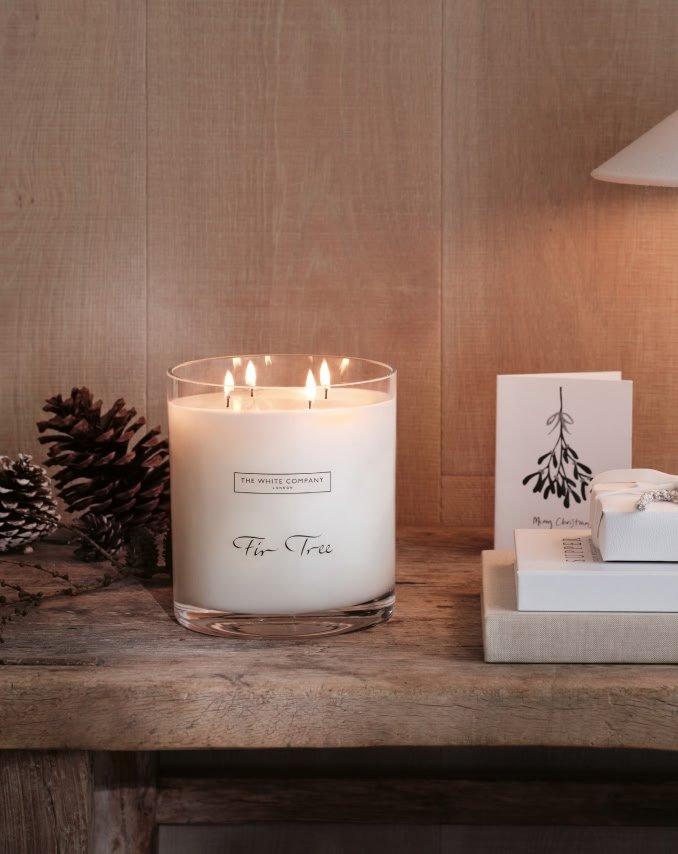 a candle on a table next to a book and a candle holder