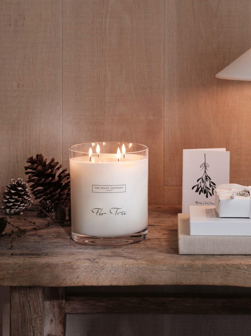 a candle on a table next to a book and a candle holder